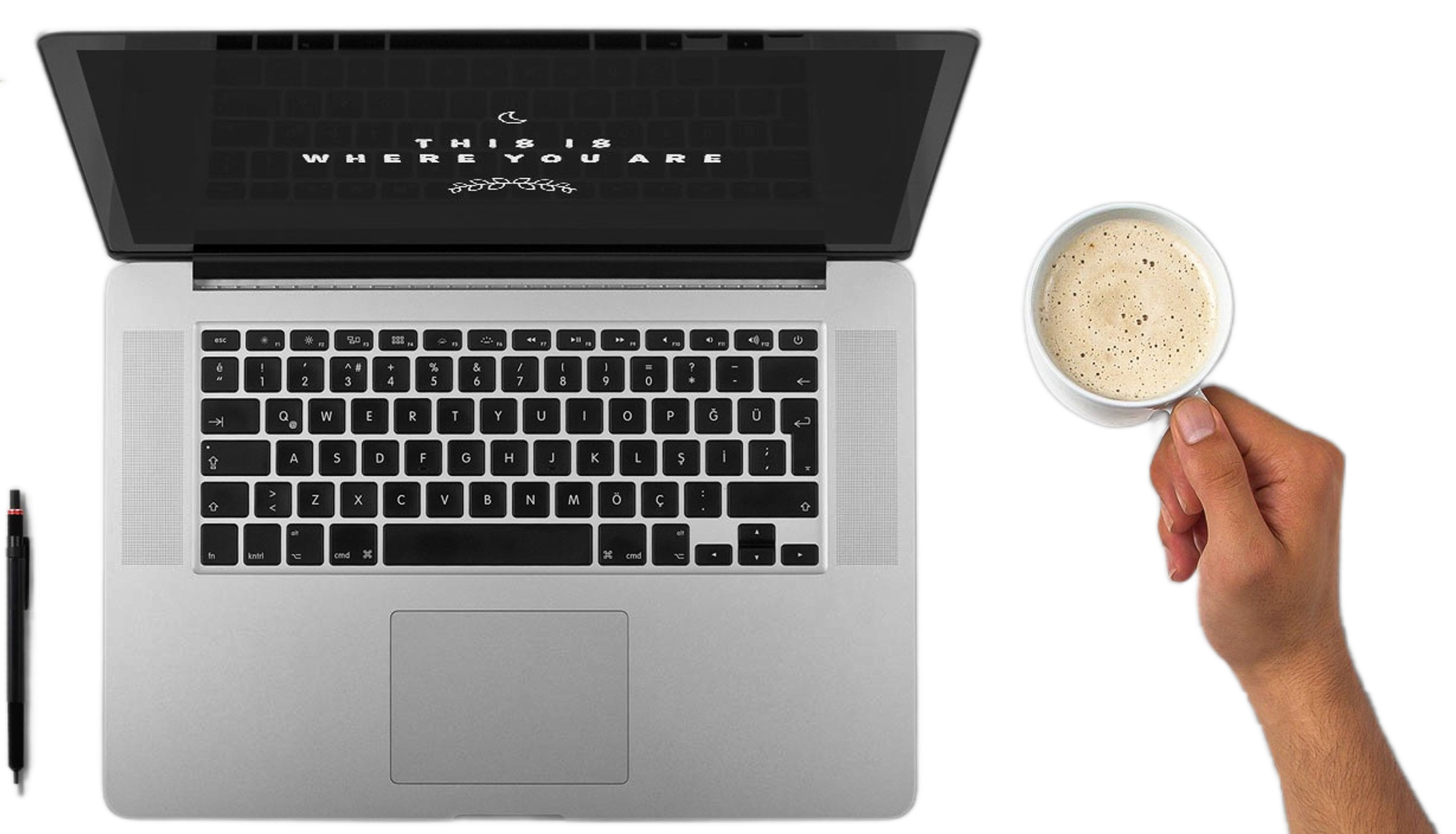 A laptop, a hand holding a cup, and a pen